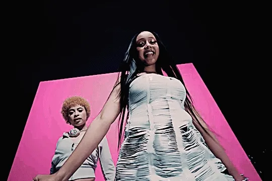 pink pantheress with ice spice in their music video for boy's a liar part 2. at night, the women dance together, ice spice in the background on the rooftop set with pink in the foreground leaning in to the camera and singing