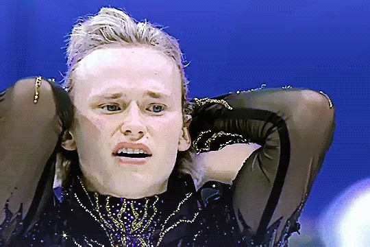 ilia with his hands on his head after running them through his hair, looking shocked and still distressed, before dropping his hands