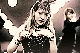 dambara ruru singing a longer note, raising her hand in emphasis as she does so