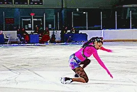starr andrews doing a small knee spin and putting a hand on the ice as part of the choreography